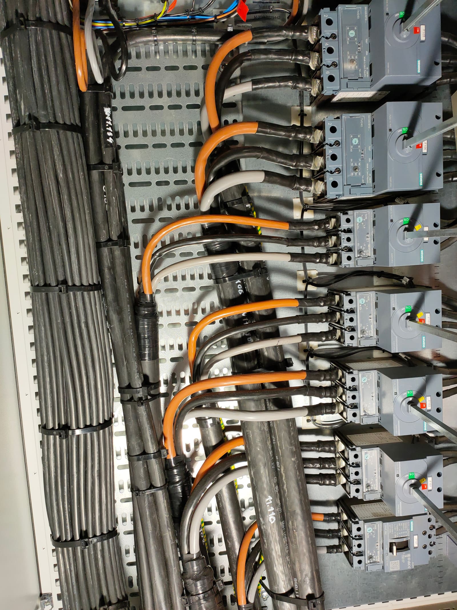 Power distribution column with each Siemens moulded-case circuit breaker fed by an orange and grey marine cable through compression lugs