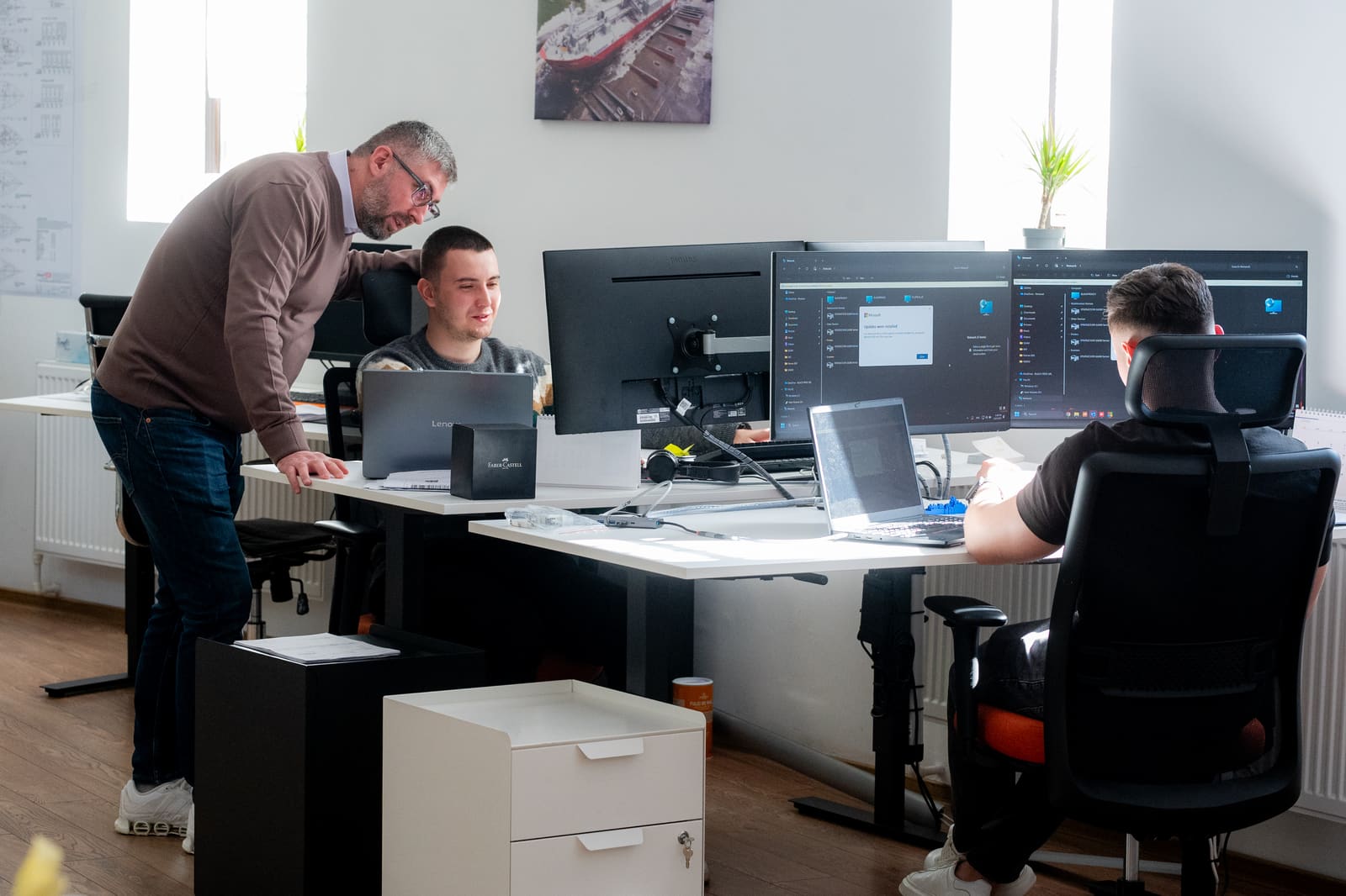 Senior engineer reviewing electrical schematics over a colleague's shoulder at the Black Frog Elektro engineering office