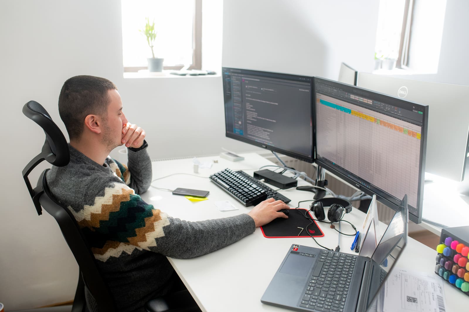 Procurement engineer tracking marine cable and equipment orders across dual monitors with project planning software