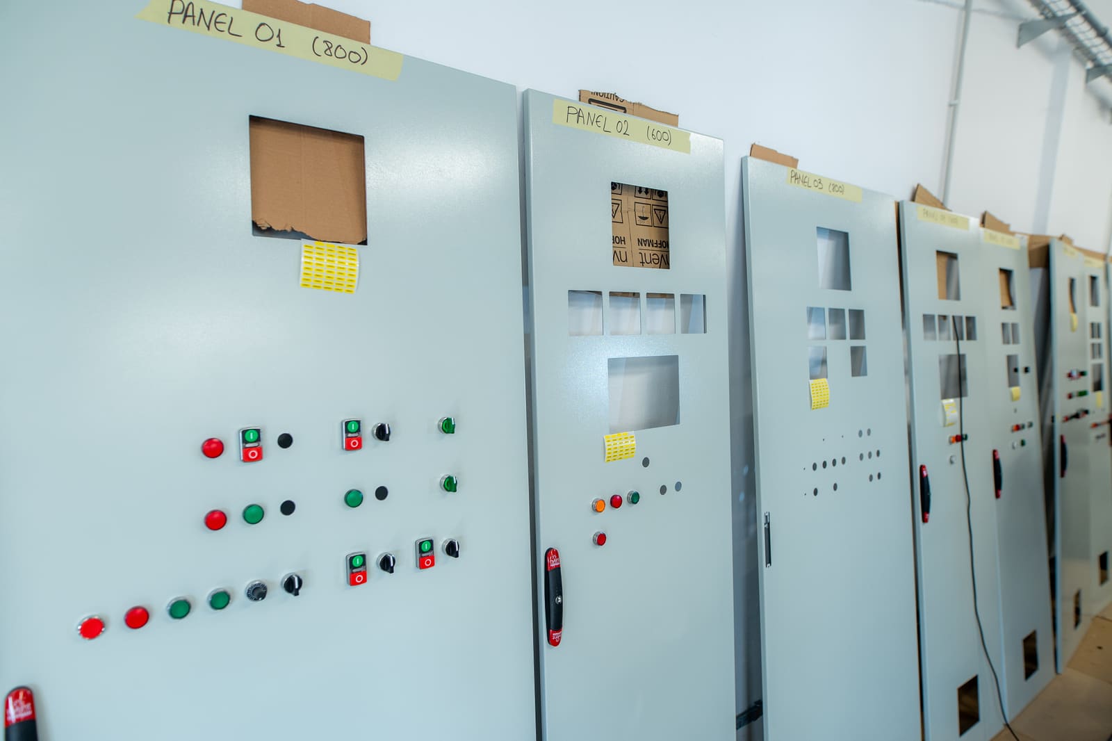 Row of marine control panels with painted enclosures and indicator lights, labelled Panel 01, Panel 02 etc., ready for fit-out