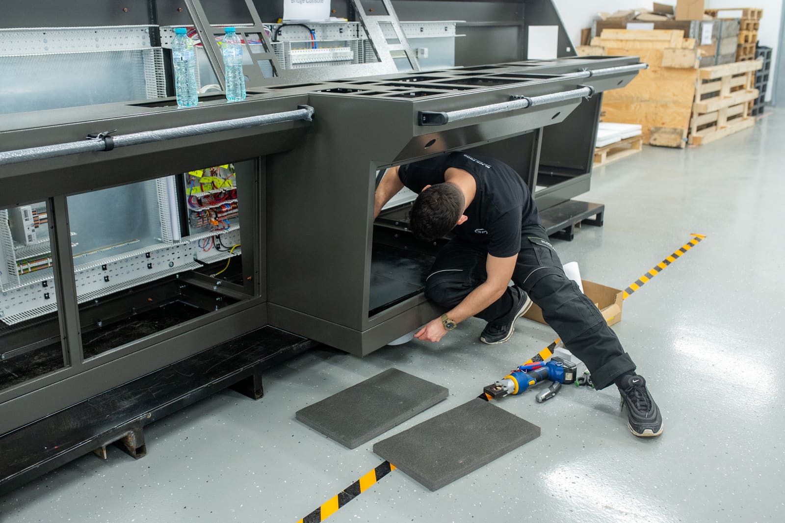 Black Frog Elektro panel builder fitting access panels onto the underside of a bridge console enclosure